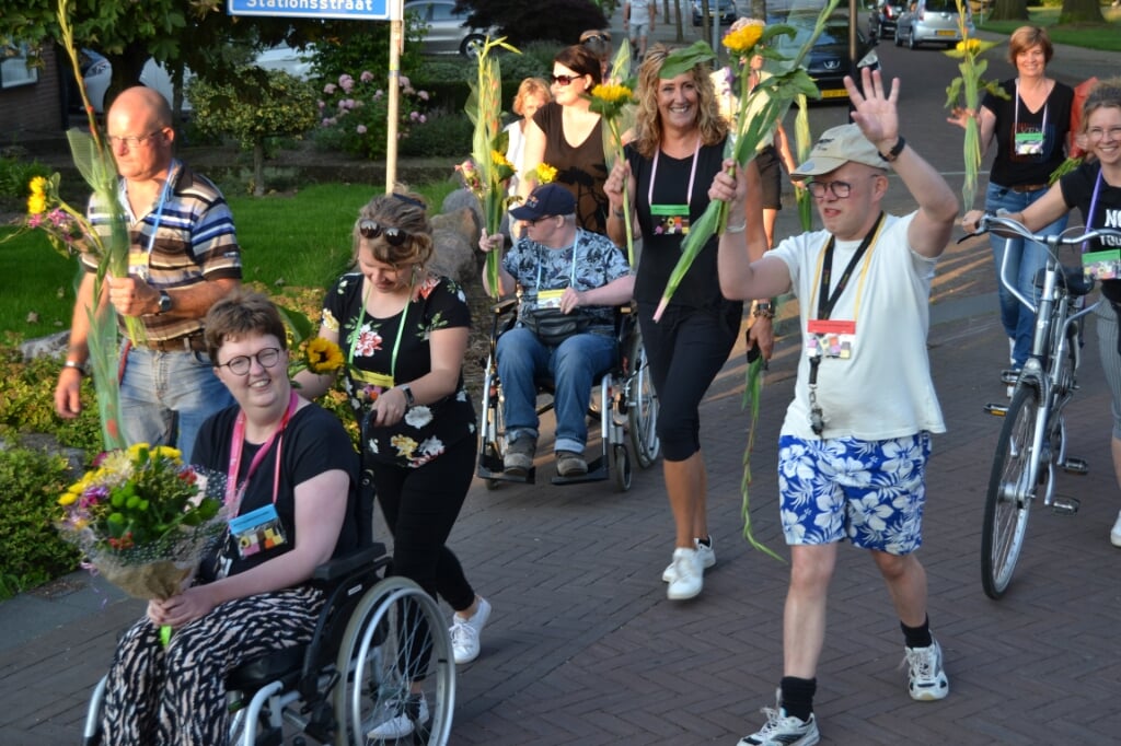 Cliënten van Estinea tijdens de 'alternatieve' Avond4daagse worden ingehaald met bloemen. Foto Karin Stronks