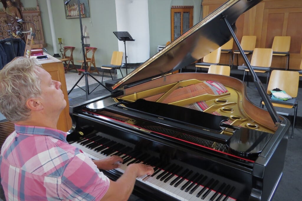 Dirigent/pianist Ben Simmes is dolblij met de nieuwe ‘Grand Piano’ in de Sint Martinuskerk in Gaanderen. Foto: Josée Gruwel