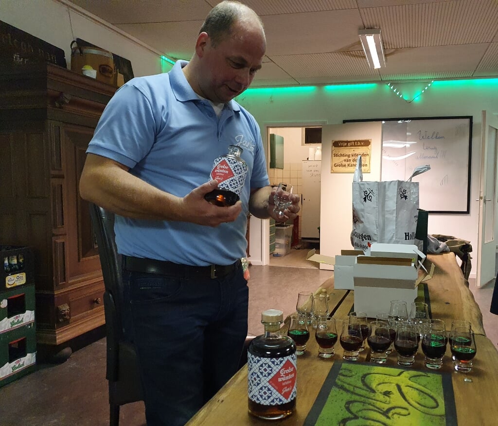 Slijter Jan schenkt voor alle aanwezigen een glaasje Grolse Wanten-likeur in. Foto: Henri Walterbos