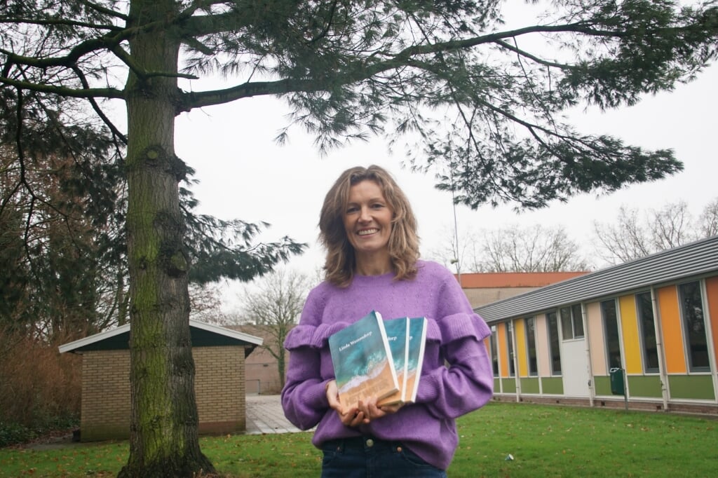 Linda Westendorp bij de 'bekende' boom met haar boeken. Foto: Frank Vinkenvleugel