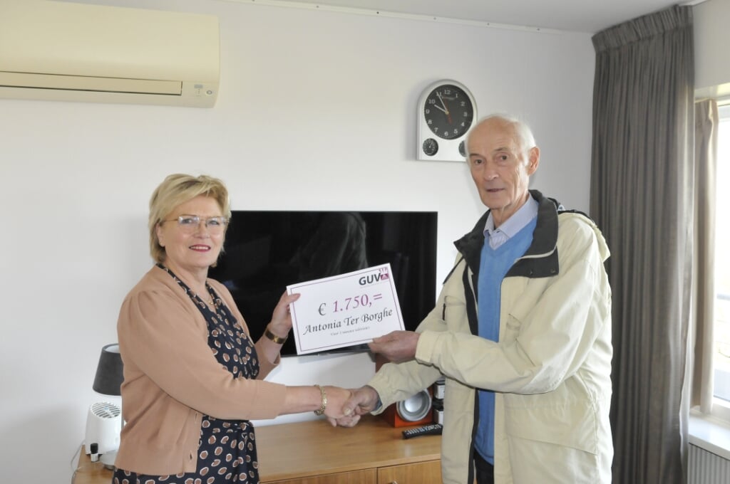 Wilma Ratering neemt de symbolische cheque voor een van de reeds geplaatste televisies in ontvangst Wim Abbink. Foto: Bert van Asselt