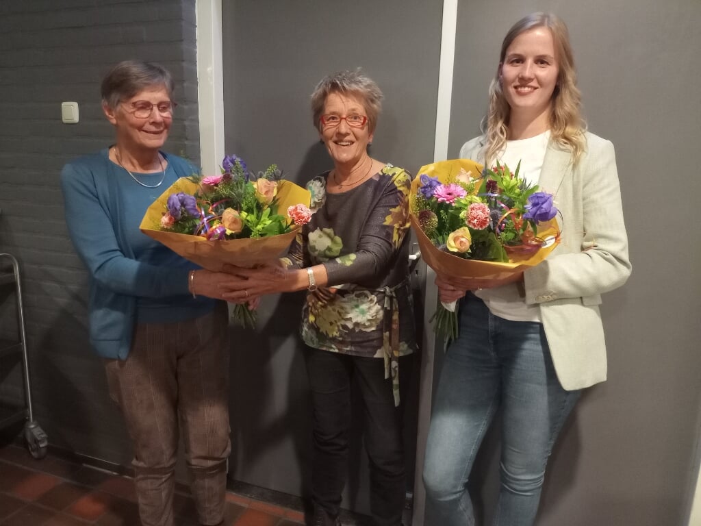 Voorzitter Ineke Rood (midden) reikt welkomstboeketten uit aan Mieke Mollenhof (r) en Sanne Schaap. Foto: Rebecca Planteijdt