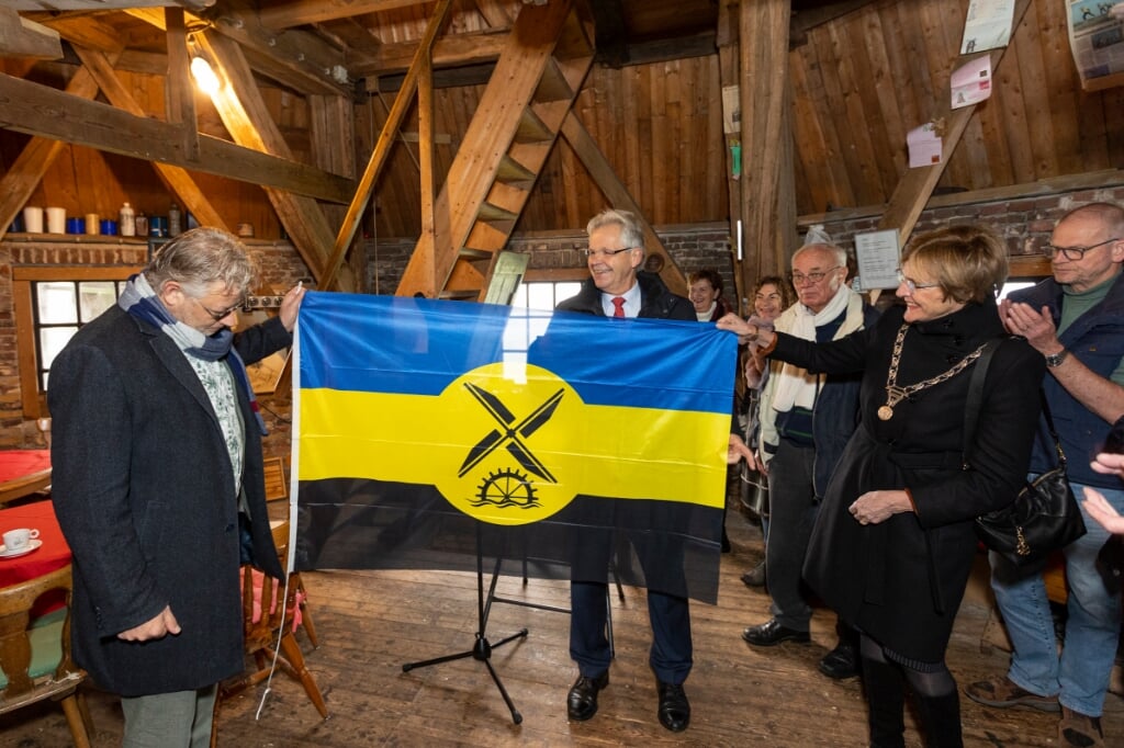 Peter Drenth, Jos Penninx en burgemeester Bronsvoort tonen de nieuwe Gelderse molenvlag. Foto: Jurgen Pillen