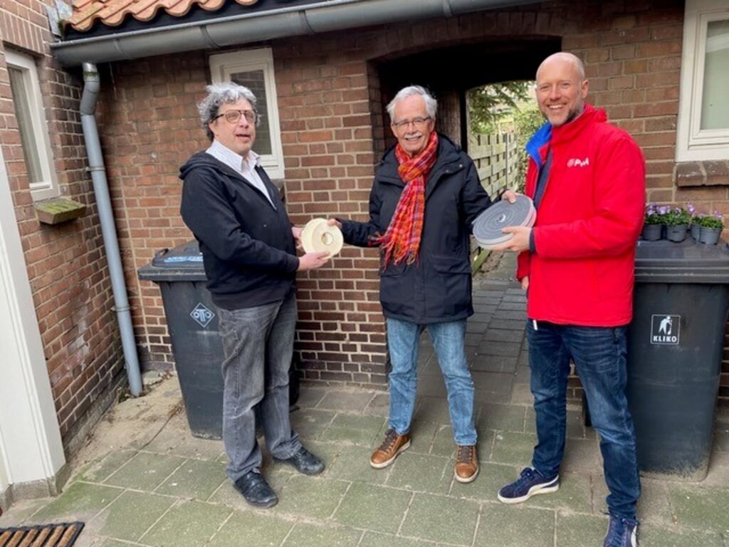 PvdA lijsttrekker Jasper Bloem overhandigt een symbolische tochtstrip aan de voorzitter van de Energiebank Herman van den Munckhof, die het doorgeeft aan een bewoner van de wijk Noordveen, Frans Eggermont. Foto: PR