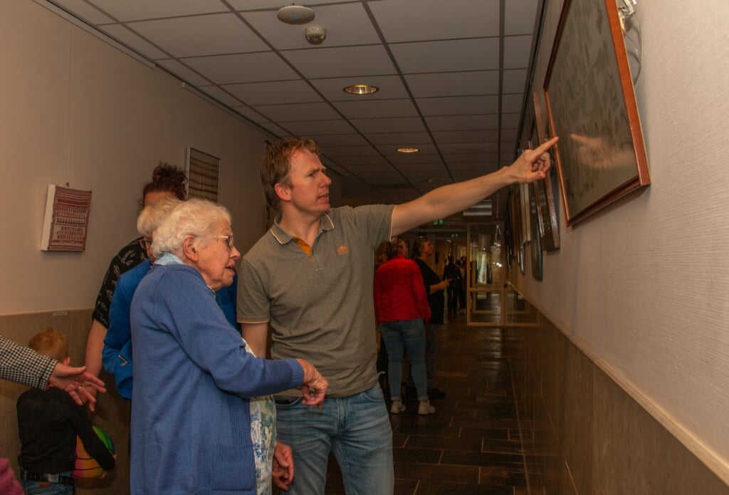 Marco Wullink kijkt met oma Mies naar het werk met de geborduurde stamboom. Foto: Liesbeth Spaansen