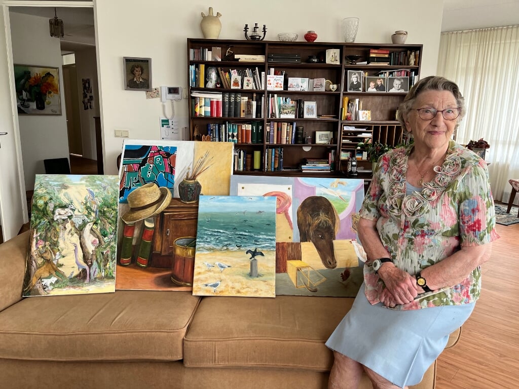 Mevrouw Jos Slootweg met enkele schilderijen die ze maakte. Foto: Karin van der Velden