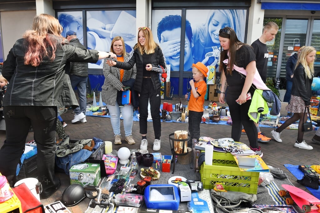 Verkoper en koper vinden elkaar op de kleedjesmarkt in 's-Heerenberg tijdens Koningsdag. Foto: Roel Kleinpenning 