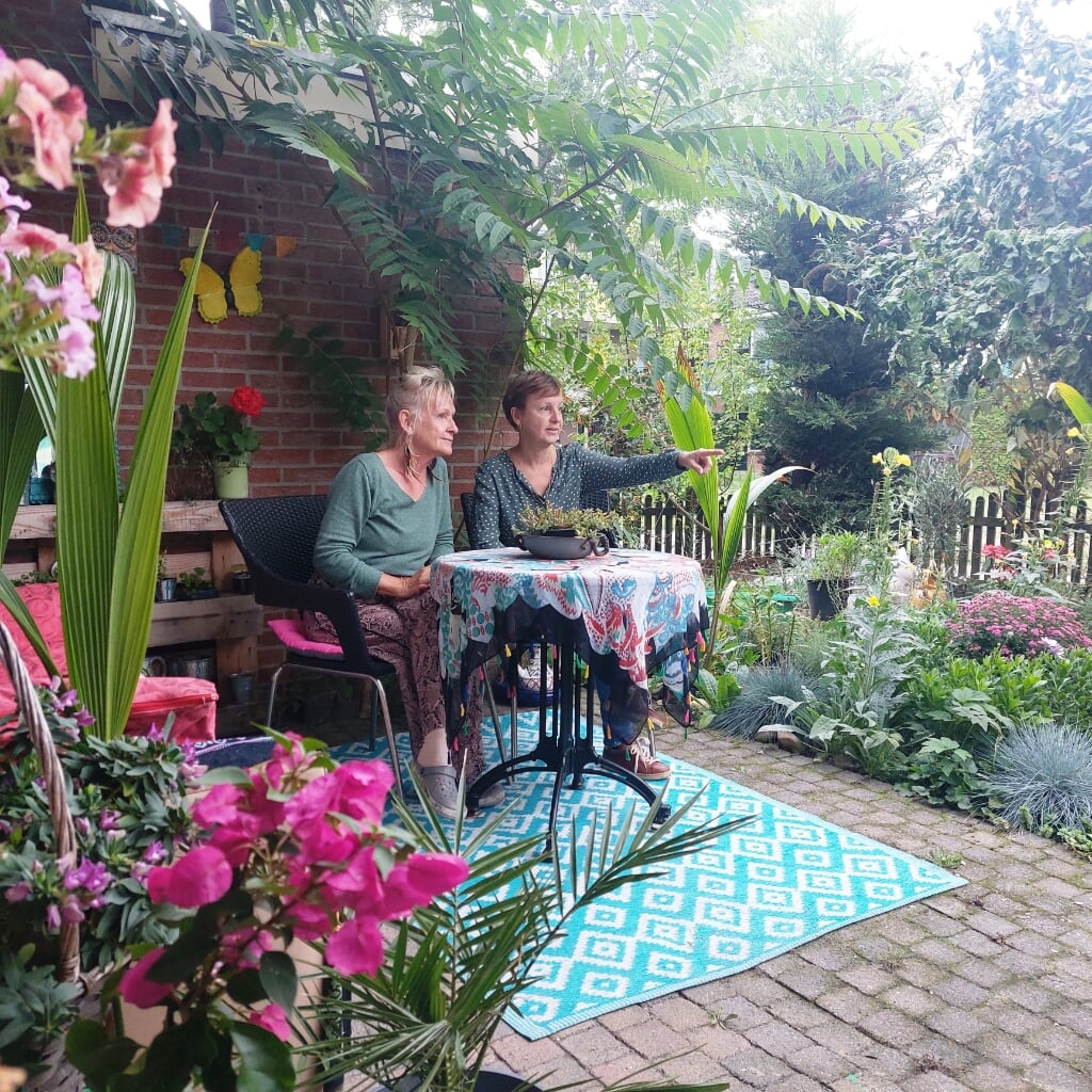 Saskia Benders (r) adviseerde Els Dijkman vorig jaar over haar tuin. De stenensjouwers deden het zware werk. Els is nu dolgelukkig in haar groeiende, bloeiende tuin. Foto: Meike Wesselink 