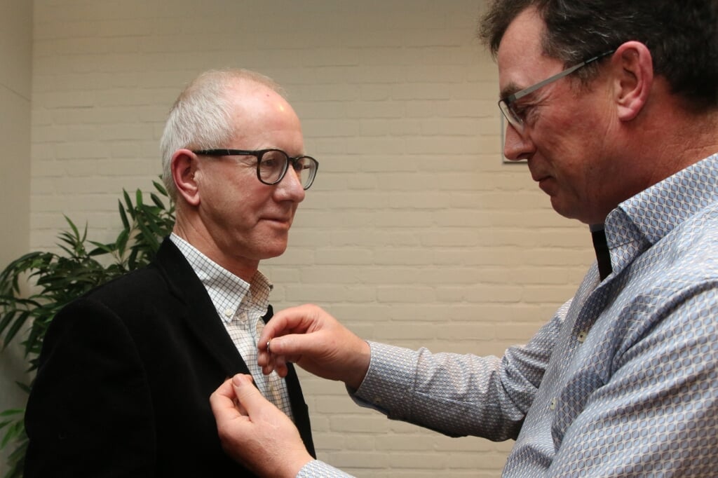 Vicevoorzitter Daniël Hakvoort speldt Gerrit Burkink de versierselen op die behoren bij het 40-jarig lidmaatschap. Foto: Theo Frencken