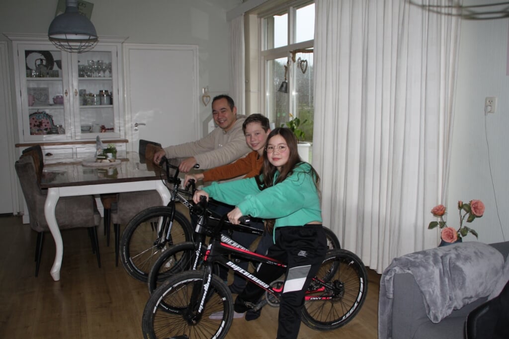 Jimmy met zijn zoon Tijn en dochter Zoë van Gessel op hun BMX-fietsen in de woonkamer. Foto: Dinès Quist