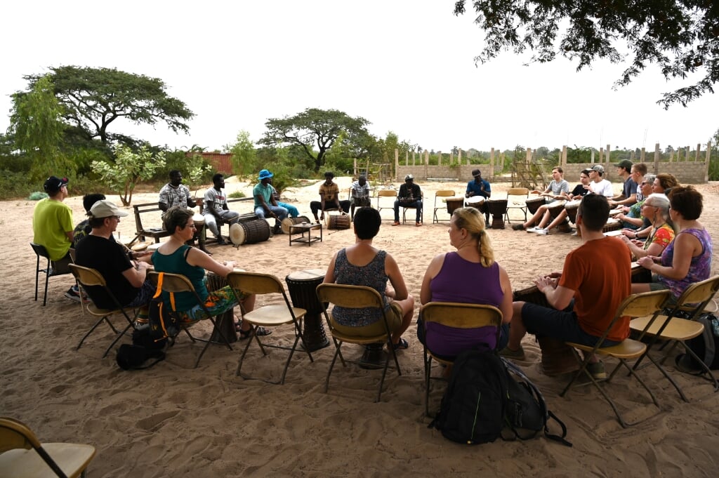 Een djembé-les in de openlucht van Gambia. Foto: Janet van Wegen