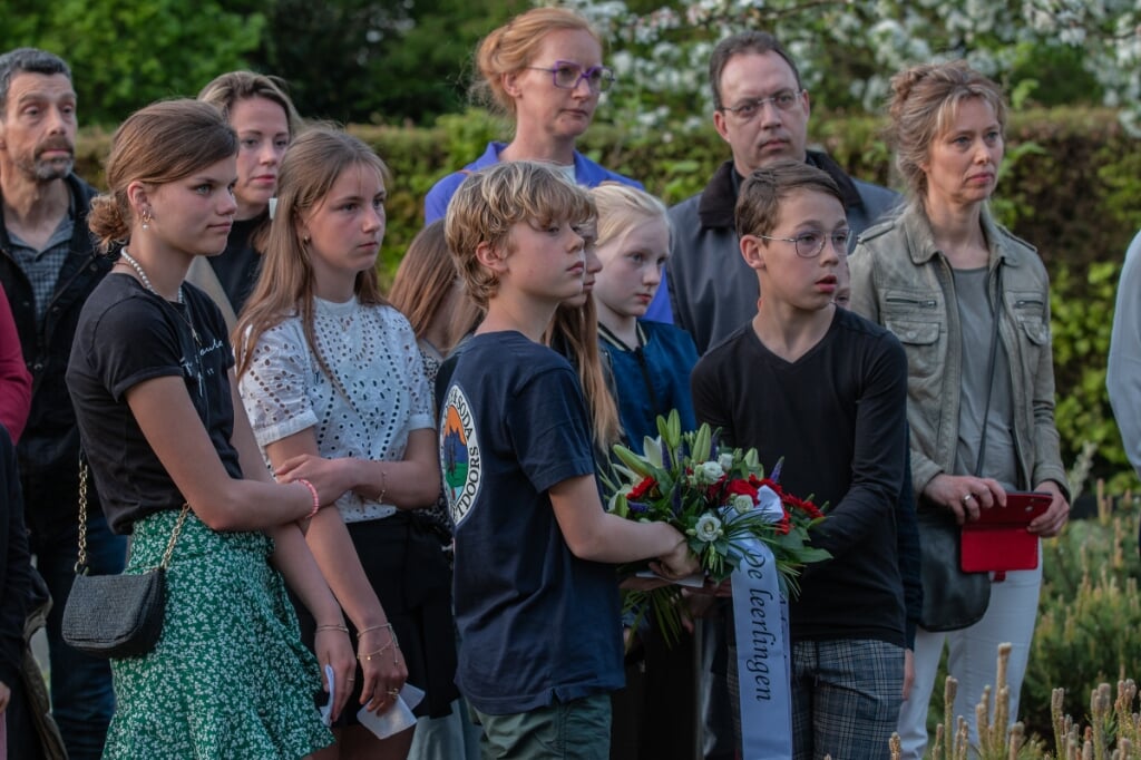 Kinderen van de Pannevogel in Steenderen hebben gedichten voorgedragen en leggen bloemen op het geadopteerde graf. Foto: Liesbeth Spaansen
