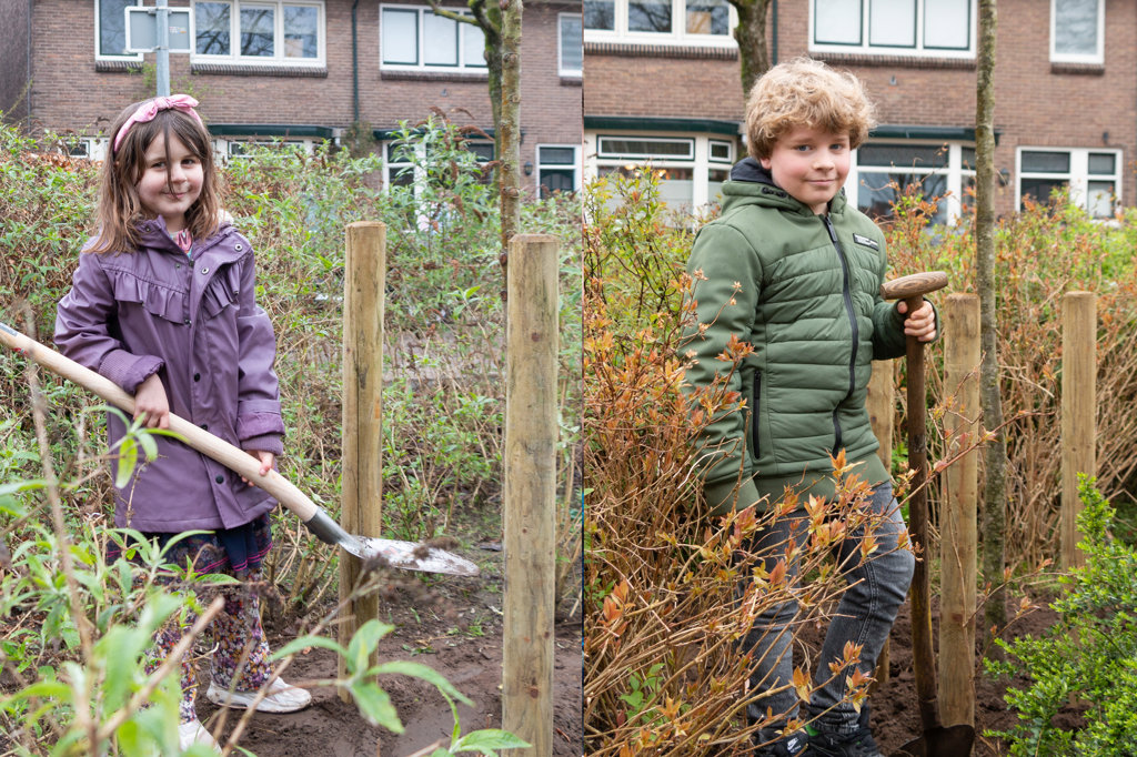 Twee van de kinderen die hebben geholpen de bomen vast in de grond te zetten. Foto: Henk Derksen