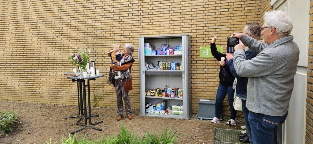 Anja Scholten en kleinzoon Ted openen de eerste voedselkast in Lichtenvoorde aan de Pastoor Sanderstraat.