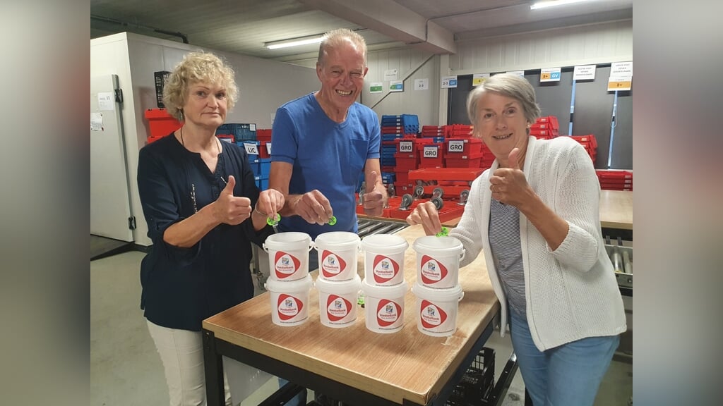 Vrijwilligers van de Voedselbank Oost-Achterhoek in Lichtenvoorde met de emmertjes waarin de kermismunten gedeponeerd kunnen worden gedurende de Lichtenvoordse kermis en twee weken daarna. Foto: Henri Walterbos