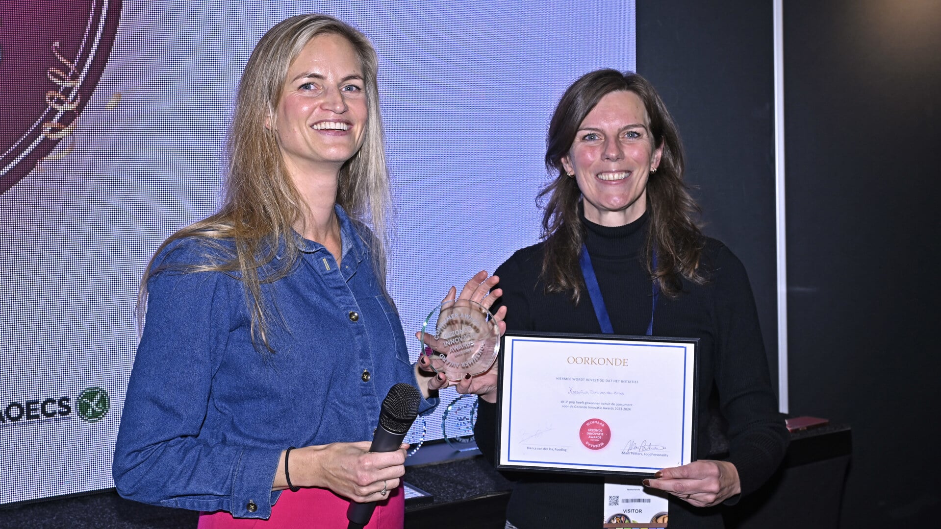 Uit handen van Bianca van der Ha (projectmanager bij Foodlog) ontvangt Tessa Agterhof (senior category manager bij Dirk van den Broek) een Gezonde Innovatie Award voor Kassafruit.