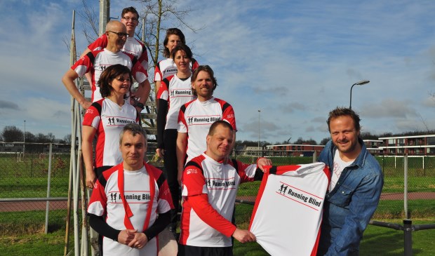 Jan Schoorl van Stichting Kees overhandigt de opvallende hardloopshirts aan de deelnemers van Running Blind.