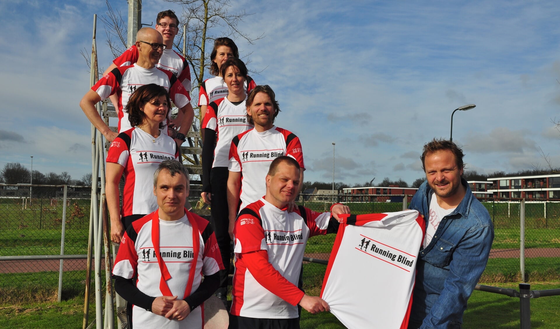 Jan Schoorl van Stichting Kees overhandigt de opvallende hardloopshirts aan de deelnemers van Running Blind.