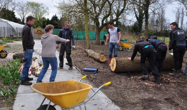 Clusius-docente Jeanine Jonker geeft aanwijzingen aan haar leerlingen, die werken aan de natuurspeeltuin.