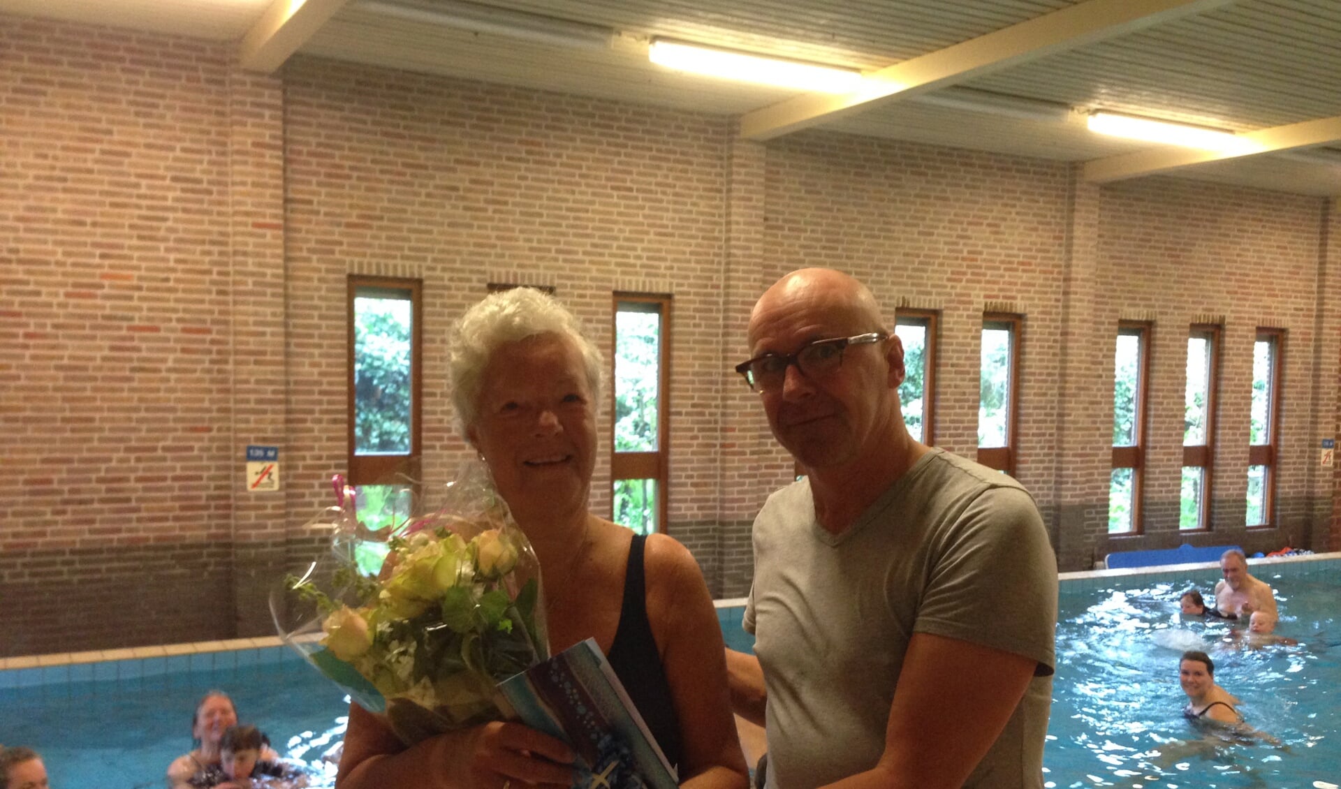 Greet Heeringa wordt in het zonnetje gezet in Zwembad Loos door SGSH-coördinator Ron Kösters. 