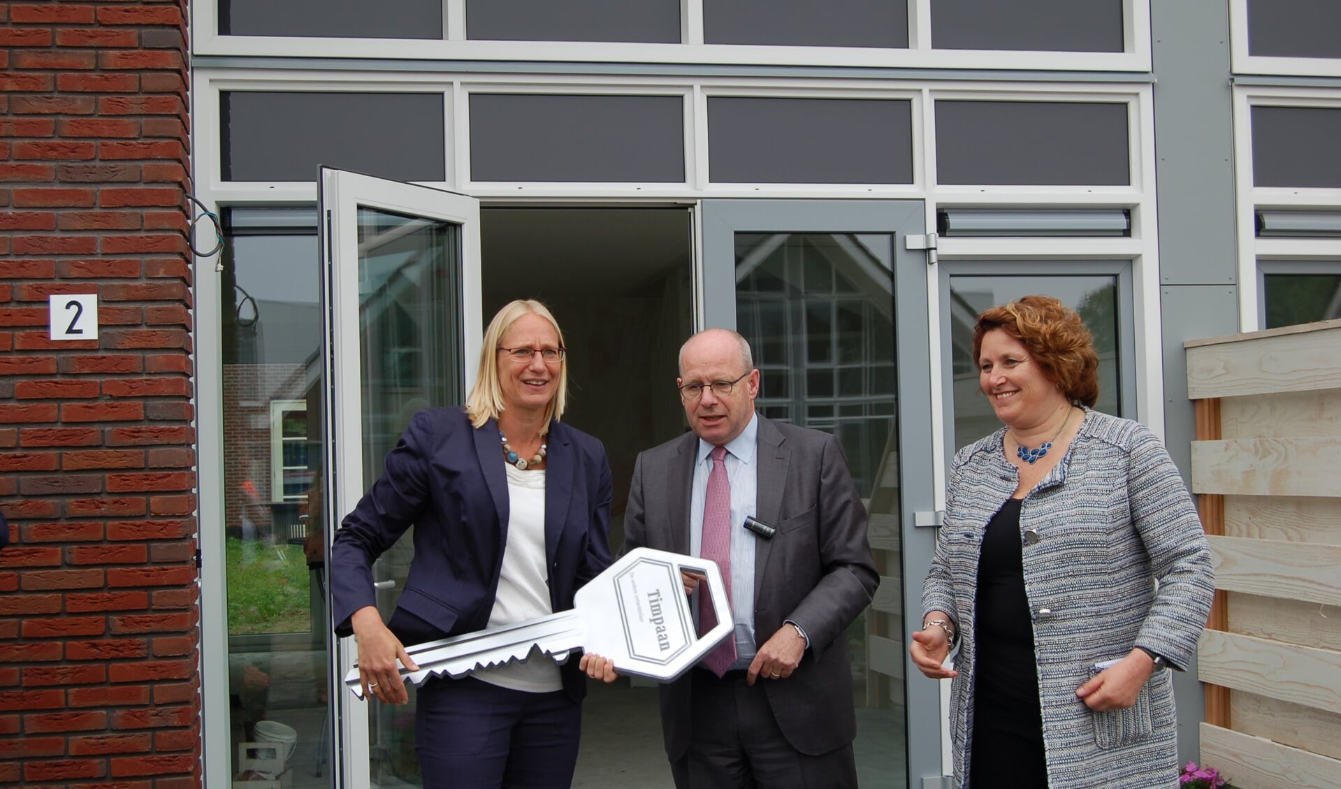 Wethouder Dellemijn reikt samen met Ingeborg de Jong (directeur Timpaan) de sleutel uit aan de nieuwe bewoonster Wendeline Velgersdijk