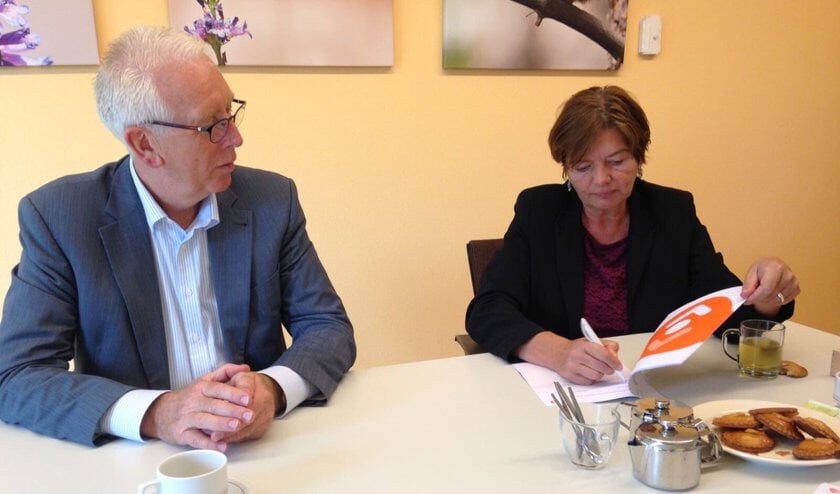 Rector Nievelstein tekent, Kees Rood naast haar.