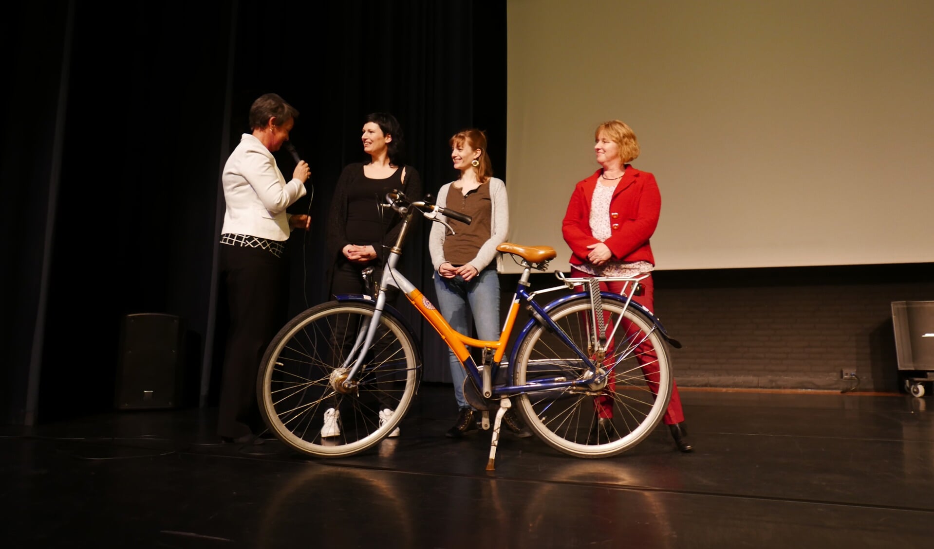 Marian van Dam (voorzitter van Rotaryclub Heiloo) overhandigt de eerste fiets aan Hilda van der Vlag, locatiemanager van AZC Alkmaar. Van links naar rechts: Marian van Dam (RCH), Hilda van der Vlag (AZC Alkmaar), Sarah Teppema (AZC Alkmaar), Lucia Admiraal (RCH).