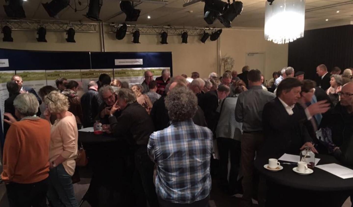 Bezoekers van de inloopavond laten zich informeren.