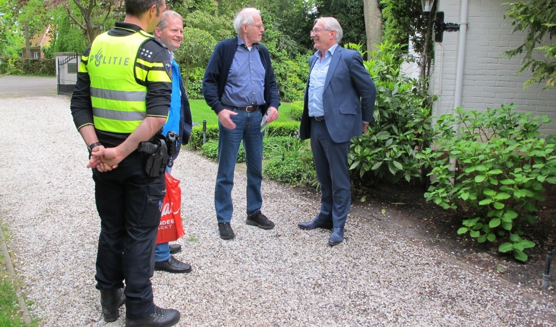 De deelnemers aan de schouw (o.a. Burgemeester Romeyn) in gesprek met een buurtbewoner. Bron: www.buurtpreventieheiloo.nl