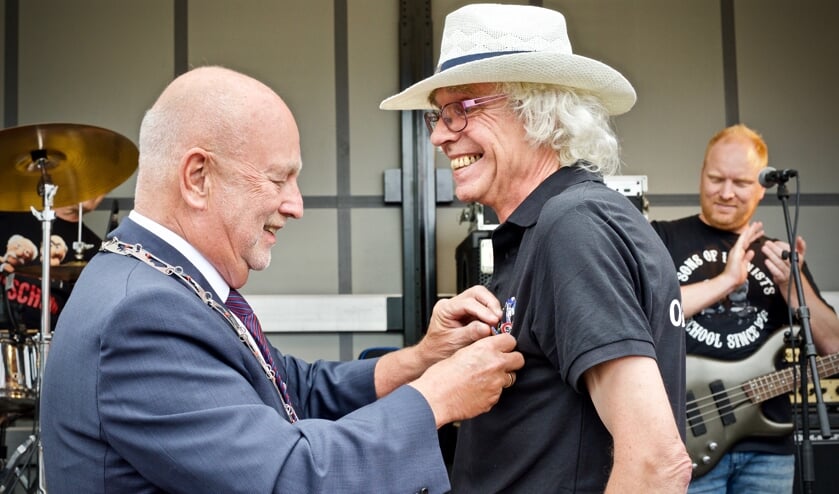 Locoburgemeester Jan Mesu spelt de Koninklijke Onderscheiding op bij Fred Valkering