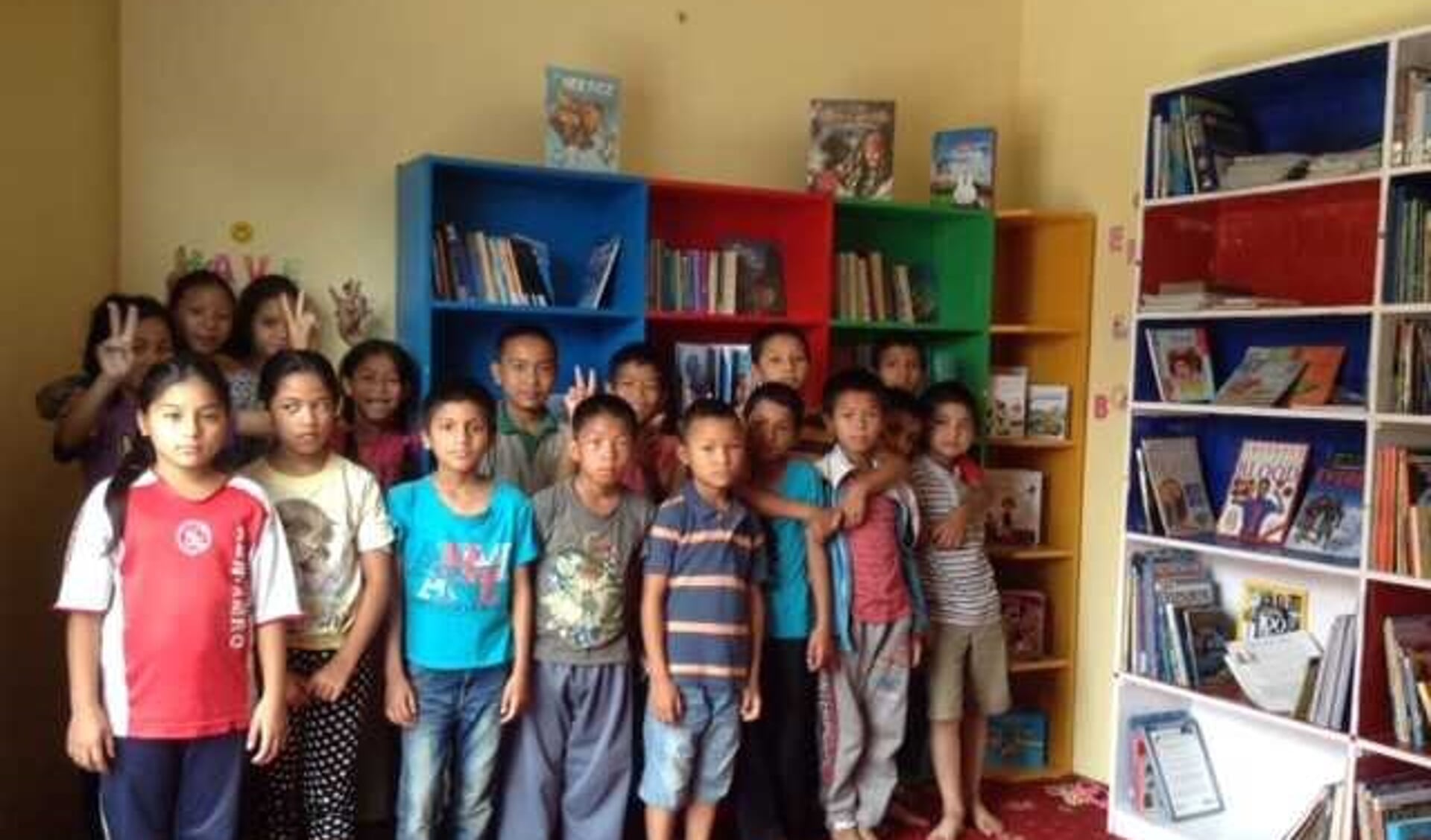 De Nepalese kinderen in de blbliotheek van het tehuis