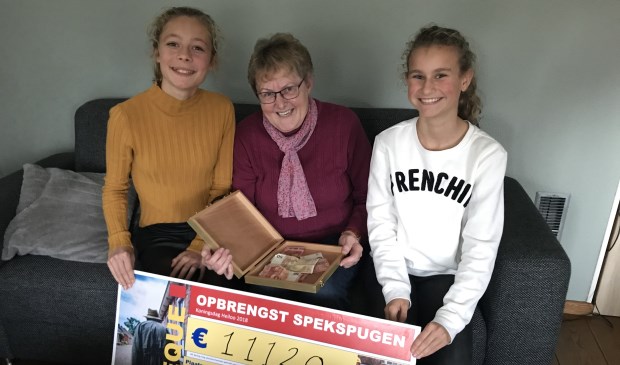 Een beduusde Willy tussen Merel (links) en Rosa (rechts) die helemaal naar Groningen gingen om haar de cheque te overhandigen.