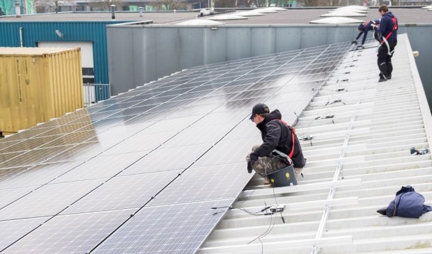 Energiecorporatie Cohesie installeert zonnepanelen op een gemeentelijk dak op de gemeentewerf,  