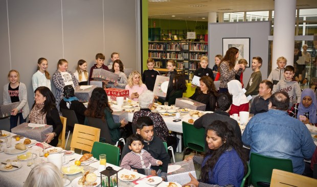 Leerlingen van de groepen 7 en 8 delen de eigengemaakte kerstpakketten uit.