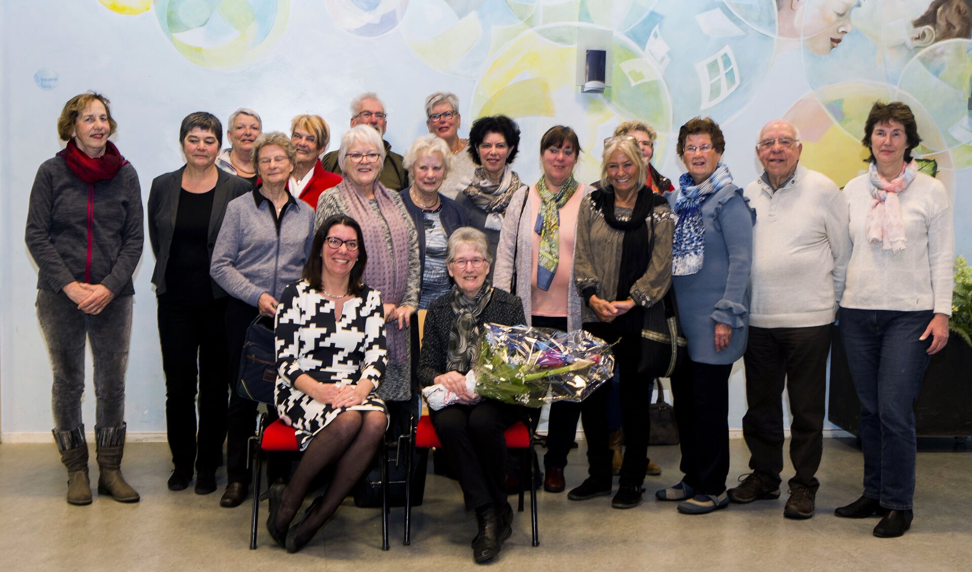 Annemiek Zoetmulder (met bloemen), ernaast wethouder De Vink en de 16 fotografie cursisten