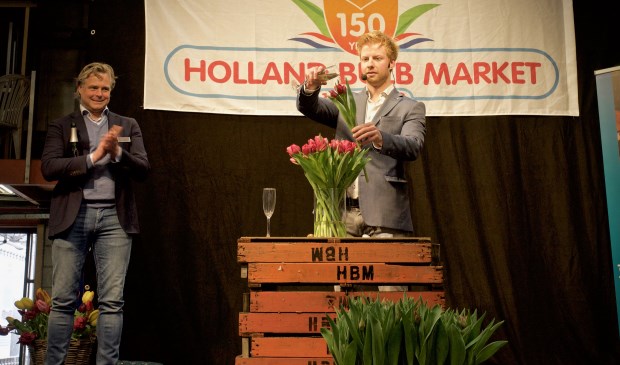 Directeur Joris van der Velden kijkt toe hoe illusionist Steve Carlin een naar hem genoemde tulp doopt.