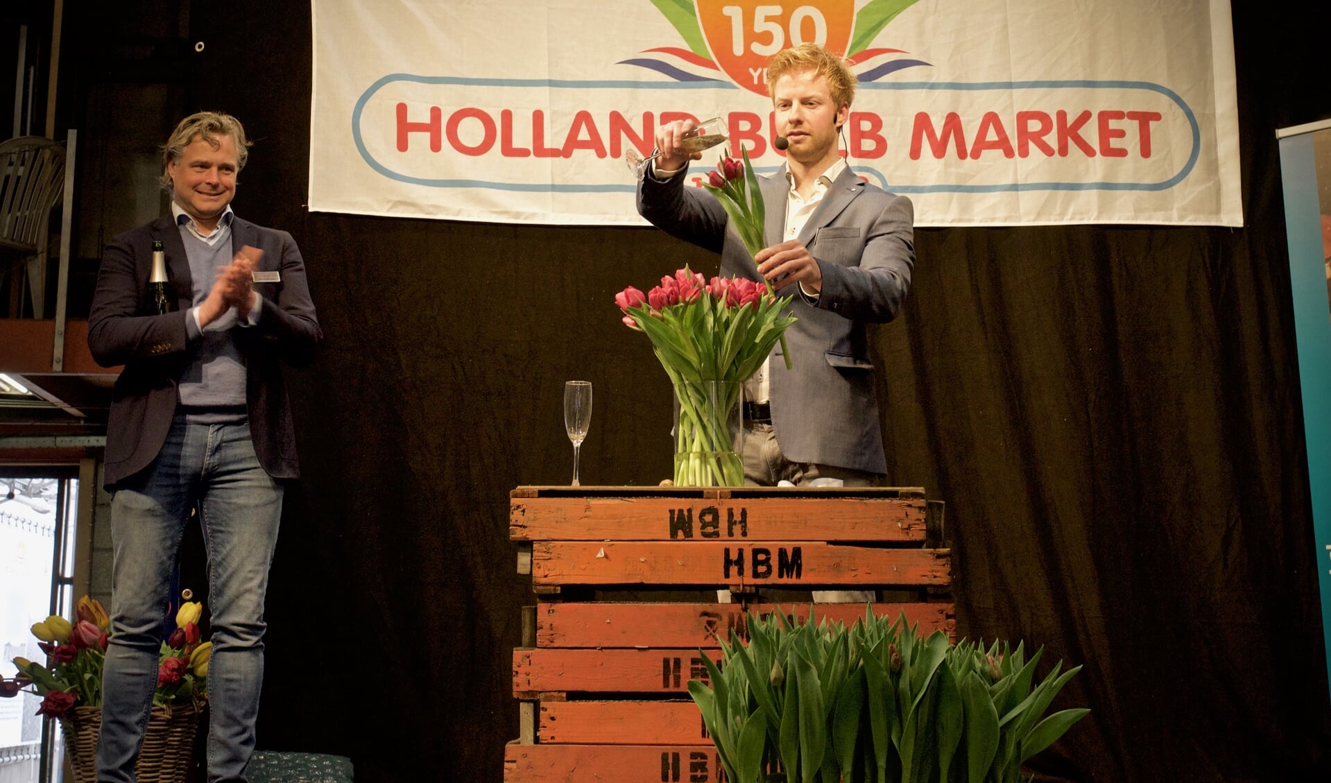 Directeur Joris van der Velden kijkt toe hoe illusionist Steve Carlin een naar hem genoemde tulp doopt.