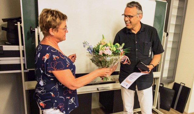 Hetty Mellink overhandigt Cris Bakker een onderscheiding.