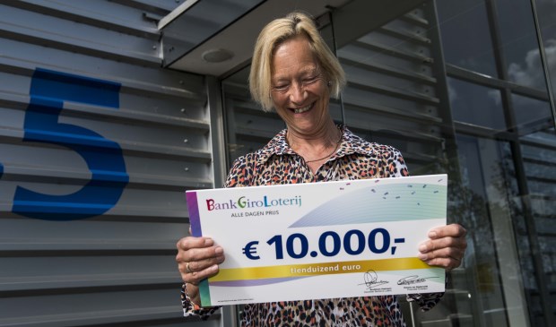 Agnes neemt blij de cheque in ontvangst.