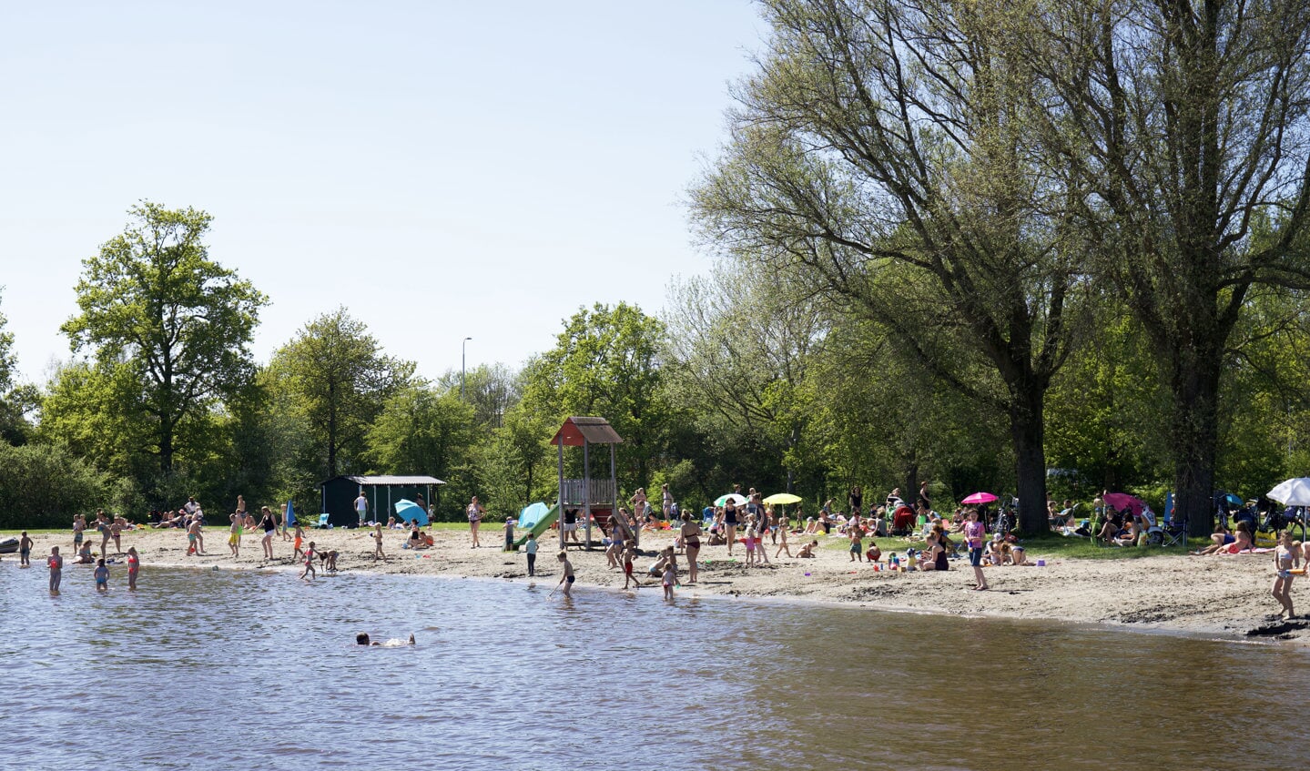 Zonnebaden aan het water bij het Uitgeestermeer. 