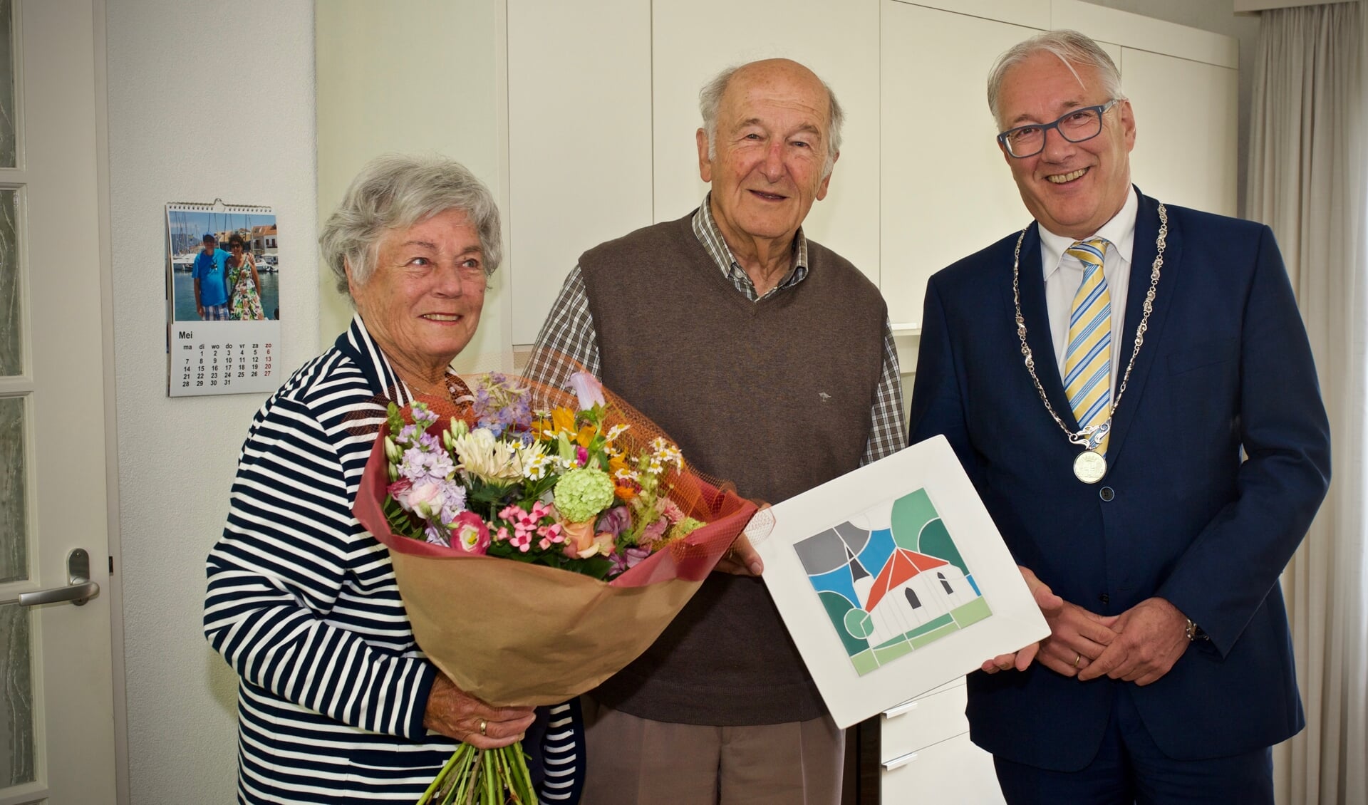 Ria van Kuijk-van West en Wim van Kuijk samen met burgemeester Hans Romeyn