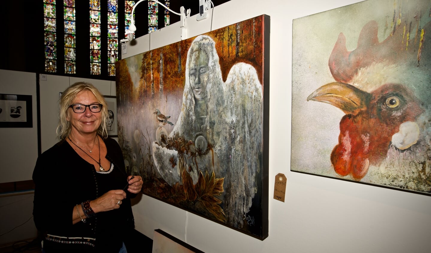 Janny van Dijk bij twee van haar kunstwerken.