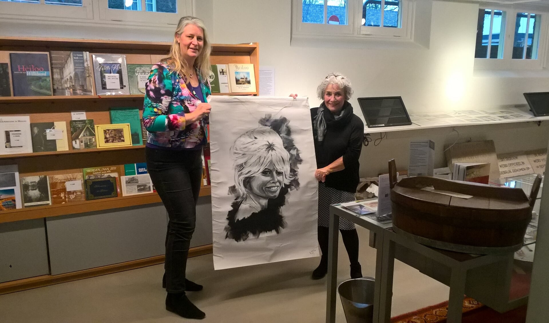 Josta de Graaf (r.) van de Historische Vereniging Heiloo overhandigt het kunstwerk aan kunstenares Jolanda Verduin.