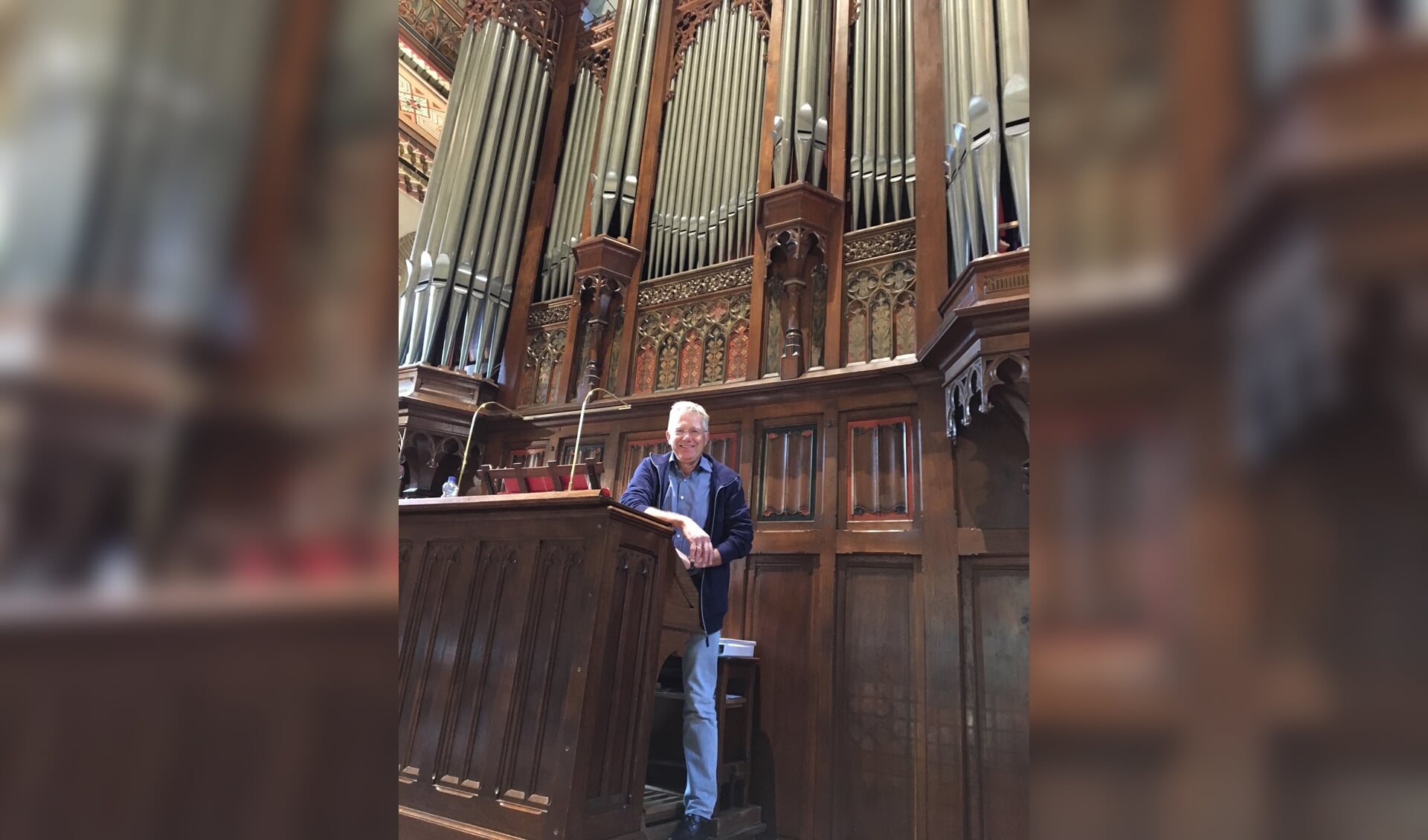 Organist Ton Schoen voor het imposante orgel in de Onze Lieve Vrouwe Geboorte kerk.