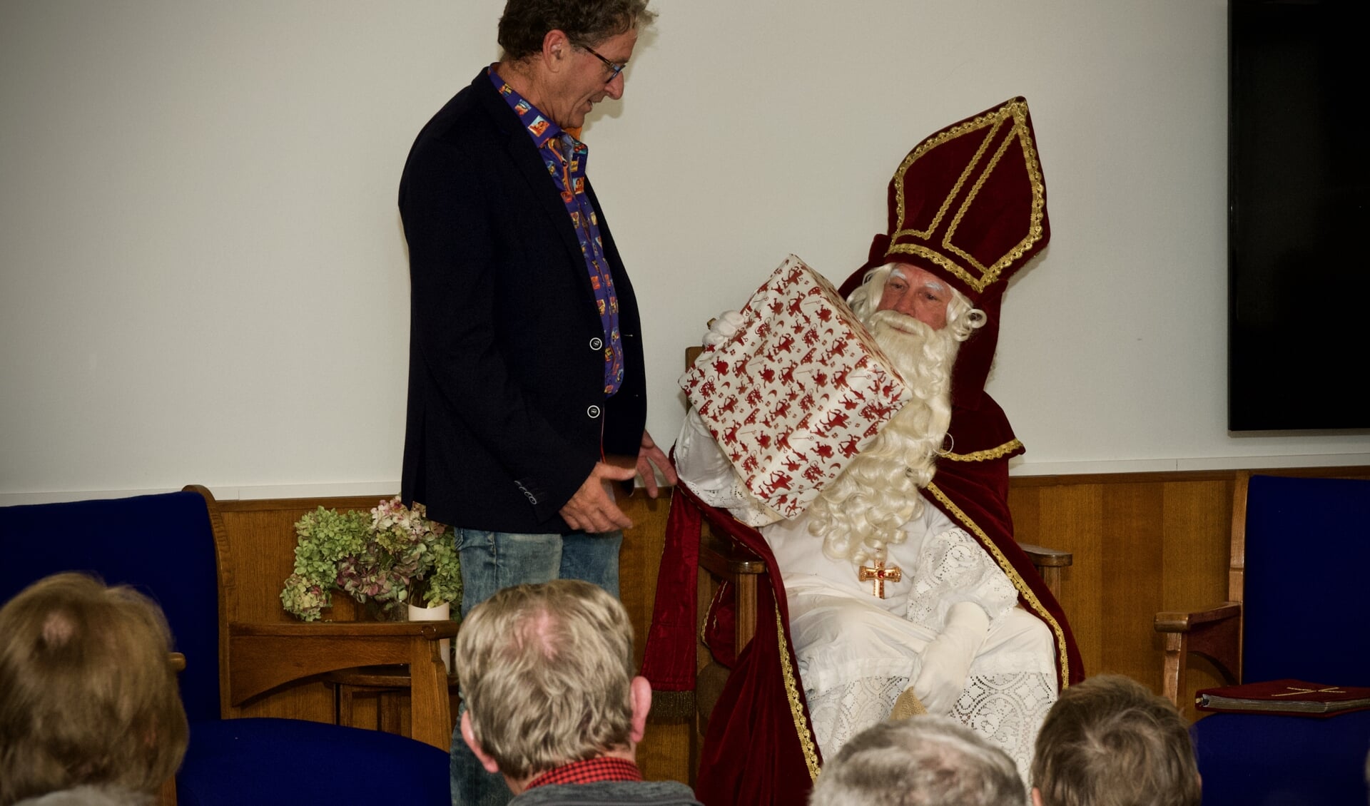 Samensteller van de tentoonstelling, Joop Tulp ontvangt van Sinterklaas een cadeautje.