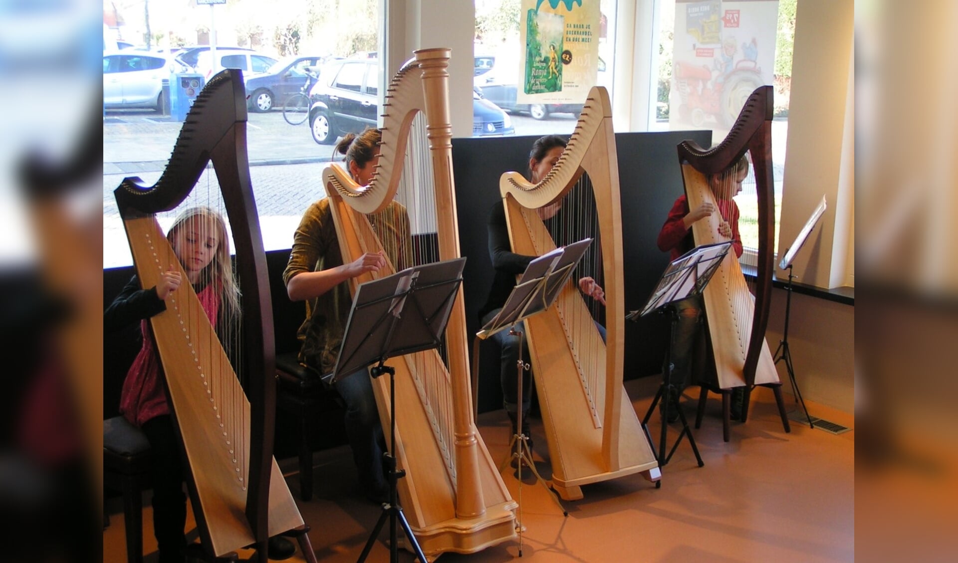 Leerlingen van de muziekschool bespelen de harp