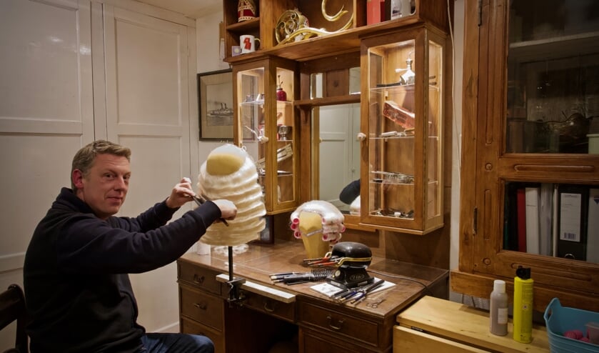 Mark in zijn atelier aan het onduleren van een baard.