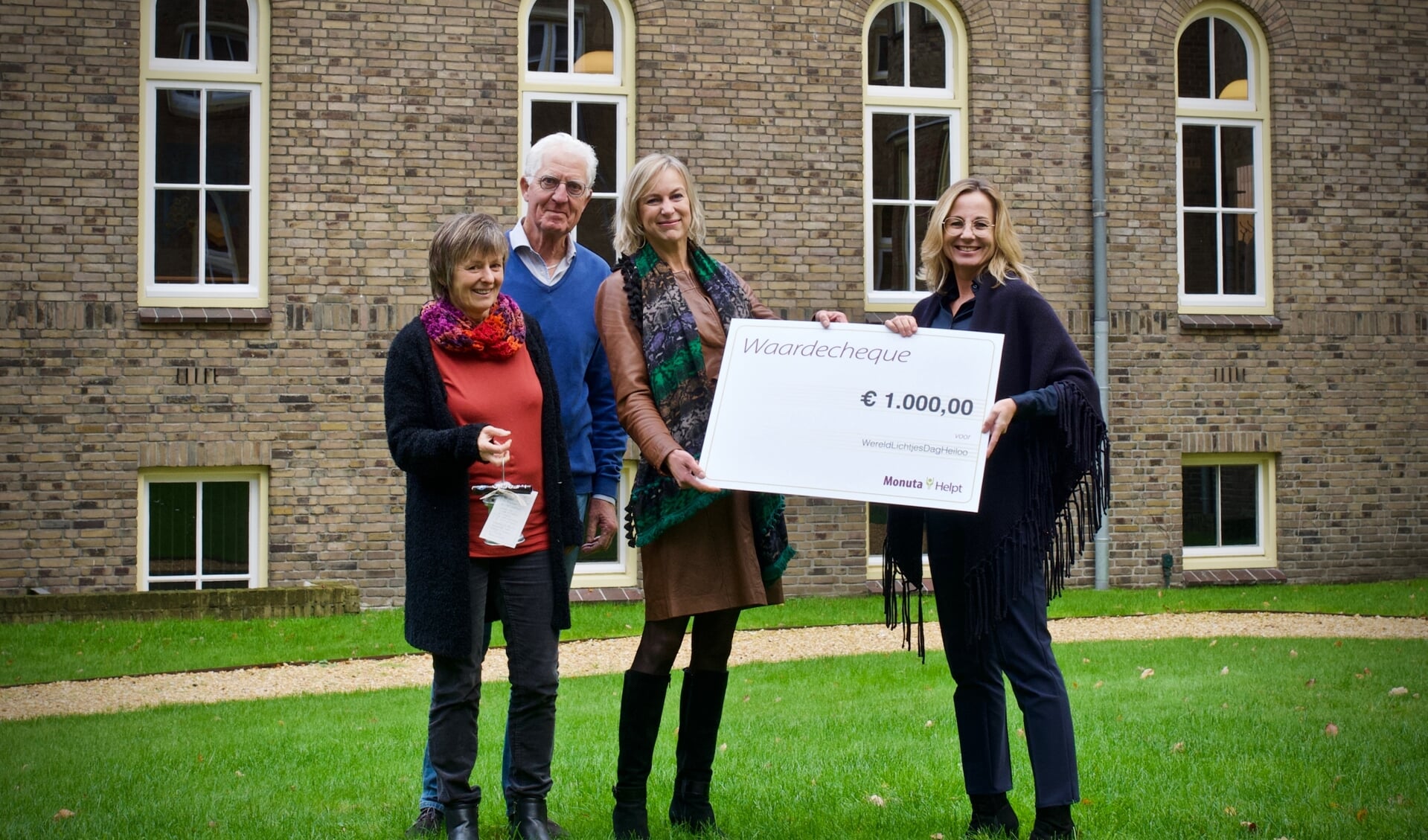Evi Velders, Aad de Wit en Anne Smaal nemen de cheque in ontvangst van Dorien Veerman.