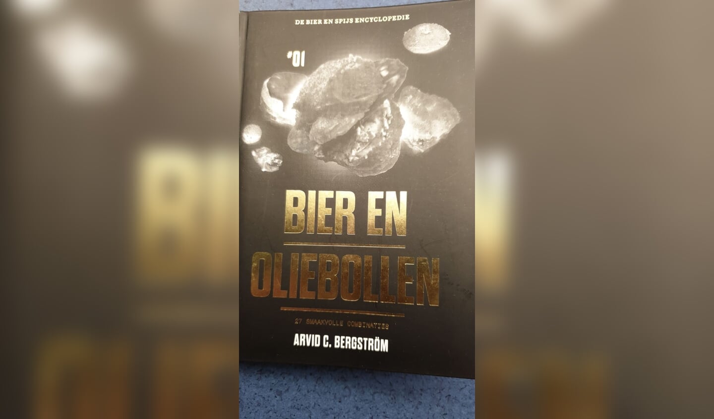 Oliebol aangeboden door winkeliersvereniging. Een gratis oliebol en boekje ter inspiratie ‘ Bier en Oliebollen’.
