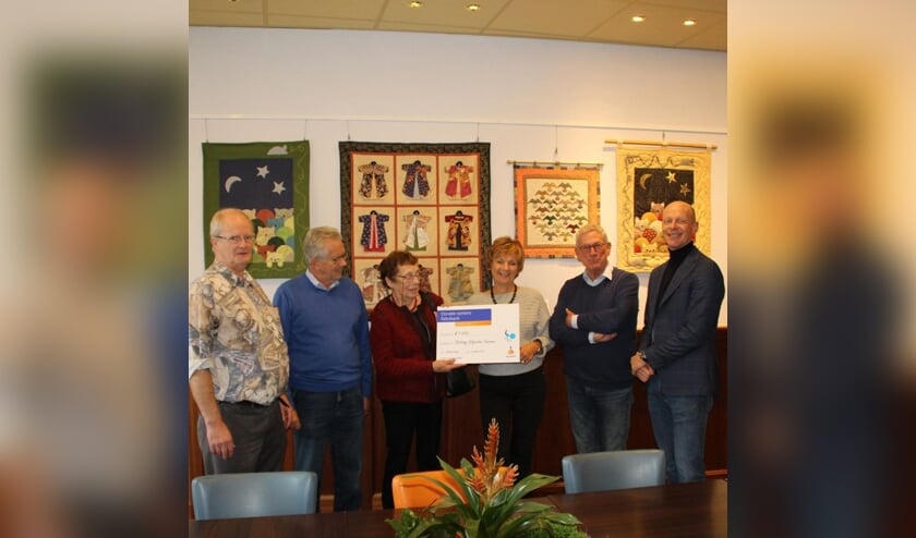 Rob Deijle reikt de cheque uit aan het bestuur van S.U.S.